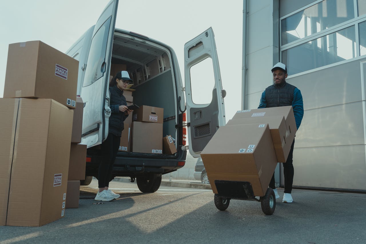 Services Two couriers load boxes into a van for shipment, showcasing logistics and teamwork.